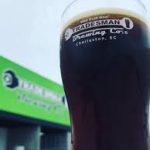 Tradesman Brewing - Pint in front of container